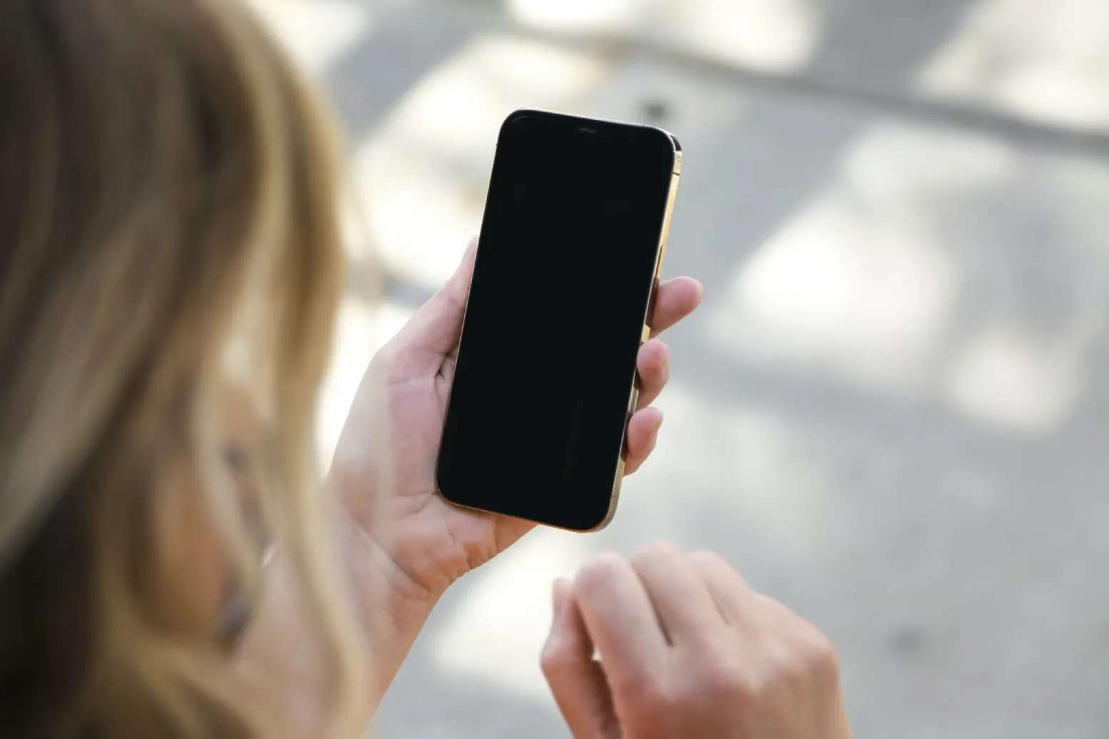 A woman holding a locked iPhone while capturing a photo with SpyCamera Pro.